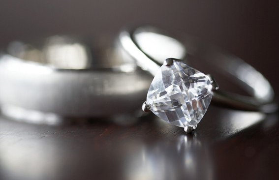 Diamond engagement ring beside a plain wedding band